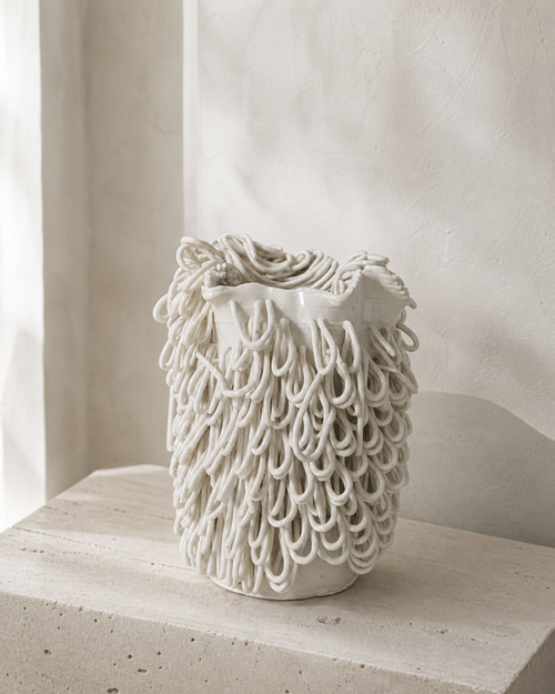 Cascade Loop Vase styled on a neutral shelf in warm natural light.