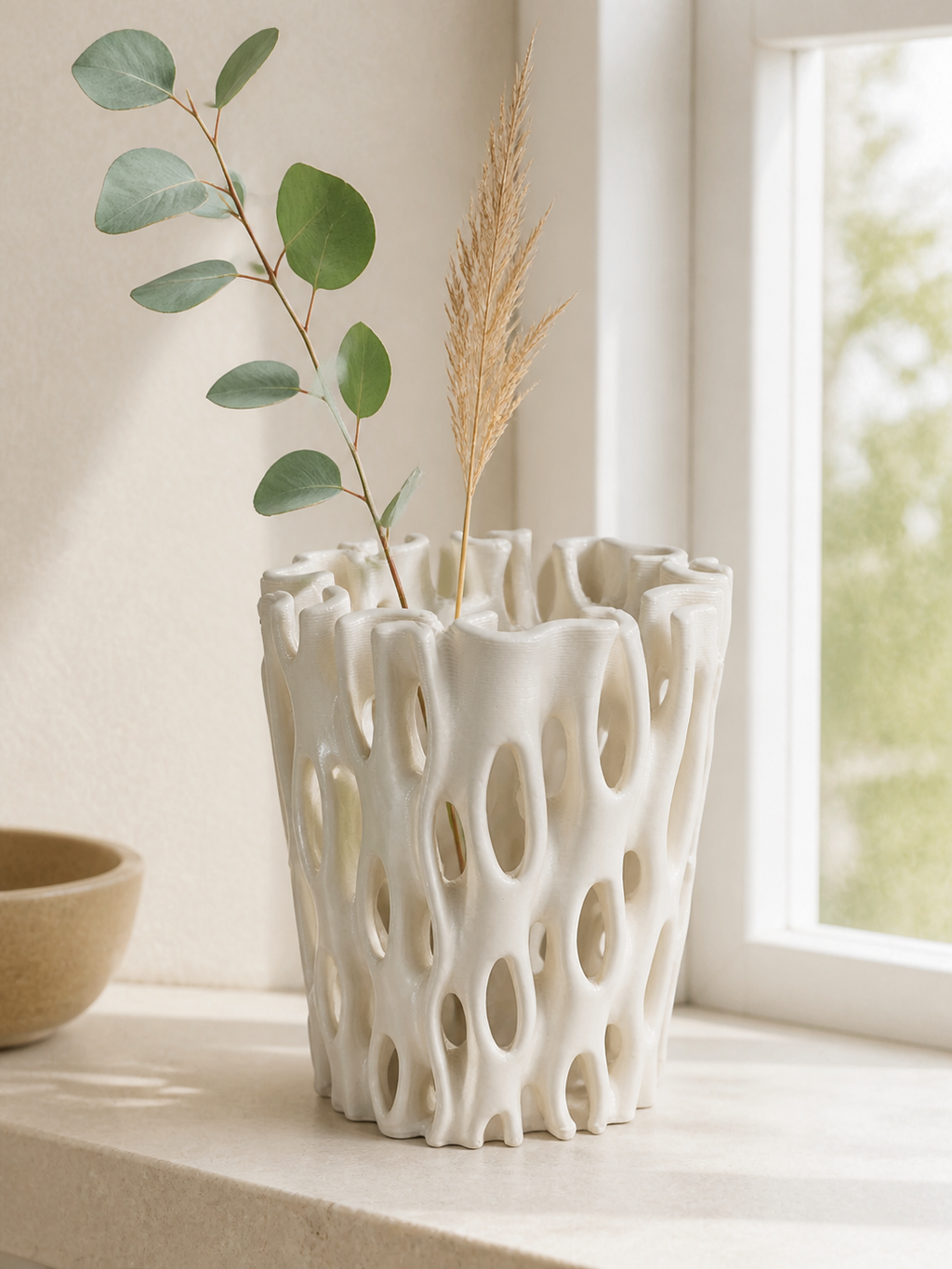 Coral Window Vase shown with sparse eucalyptus and dried grass stems near a bright window.