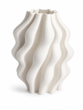 Folded Wave Vase, a warm ivory ceramic clay-printed vase with vertical folded wave ribs on a white background.