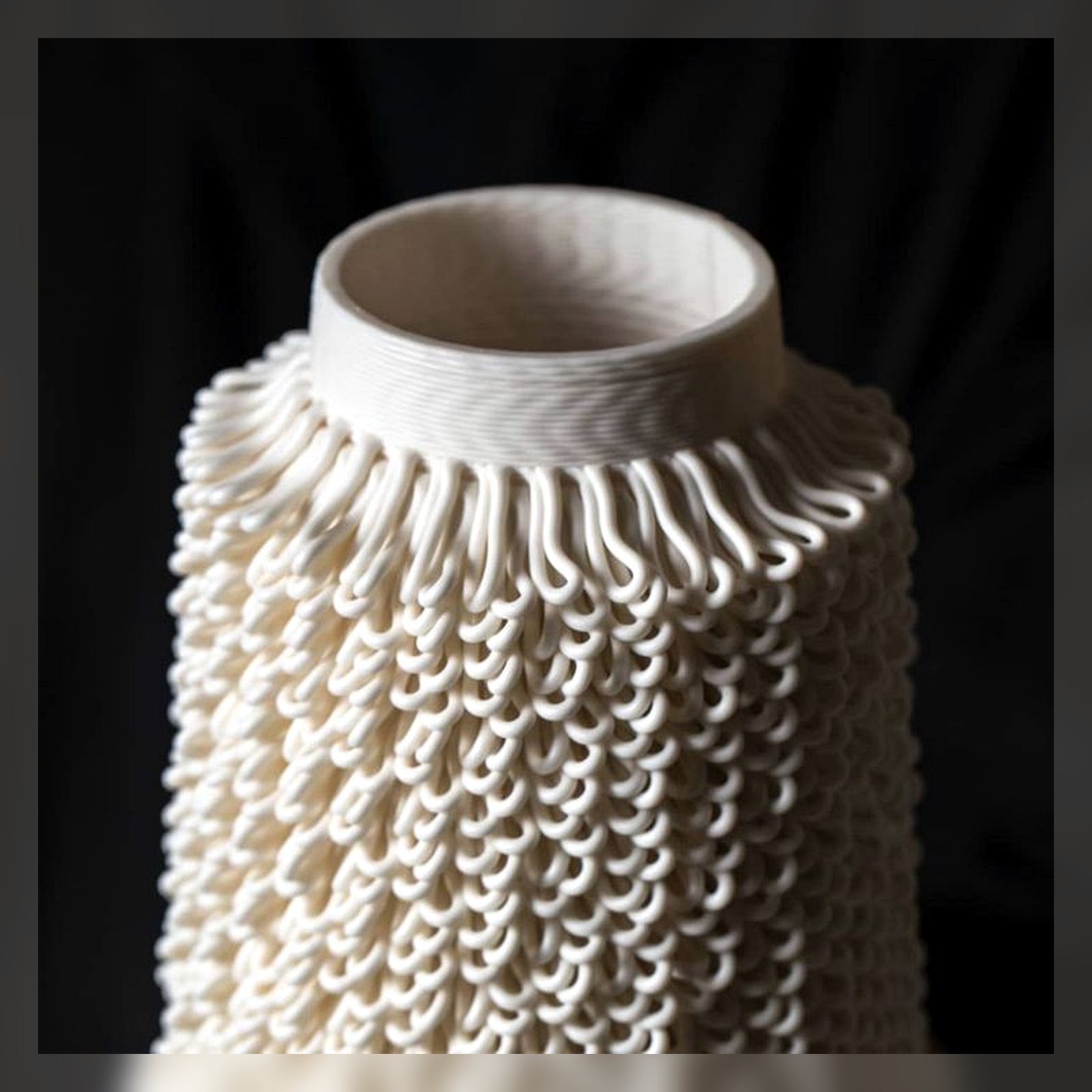 Close detail of a white ceramic vase with looping texture.