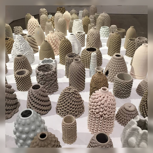 A table of varied ceramic vases and small sculptural forms.