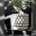 White woven-texture ceramic planter holding a small green plant.